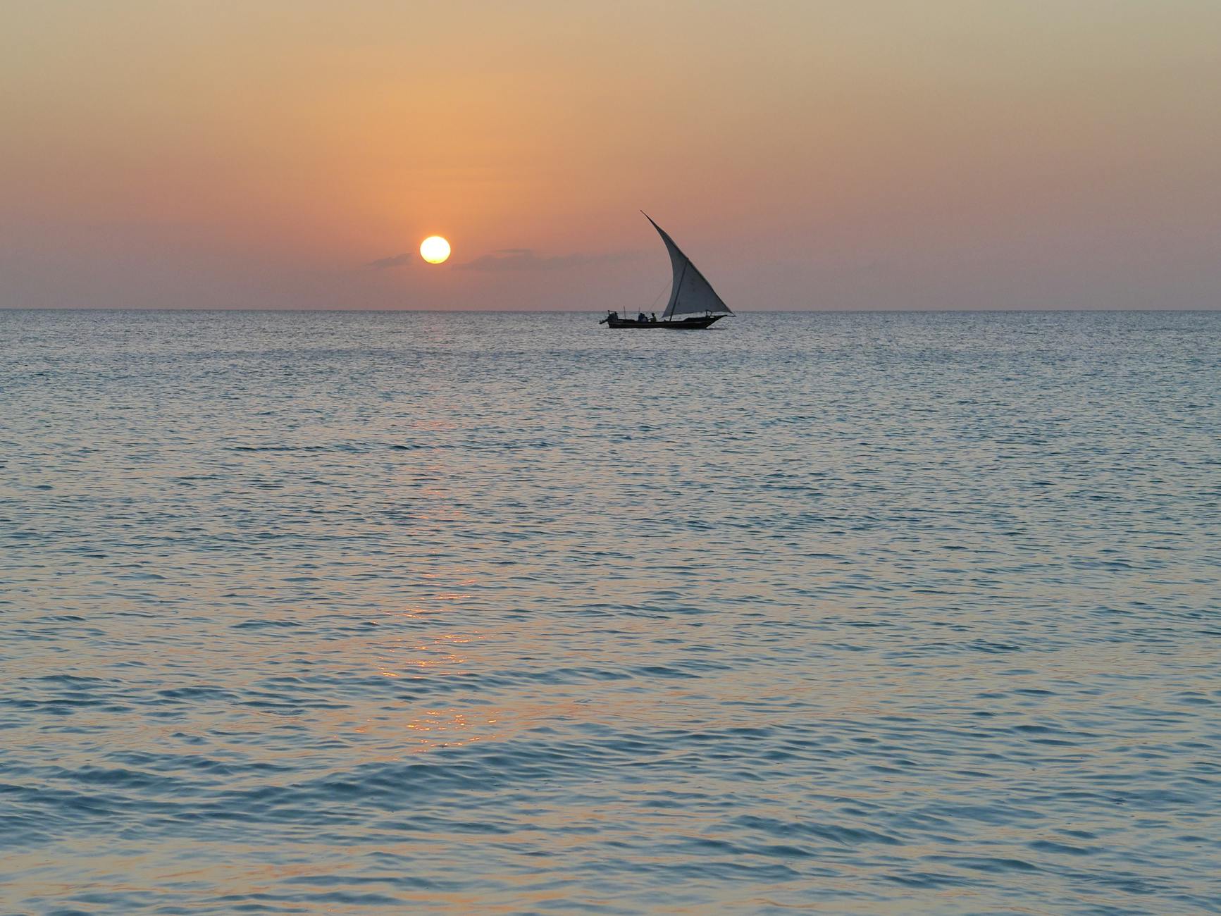 a sailboat on the sea during sunset